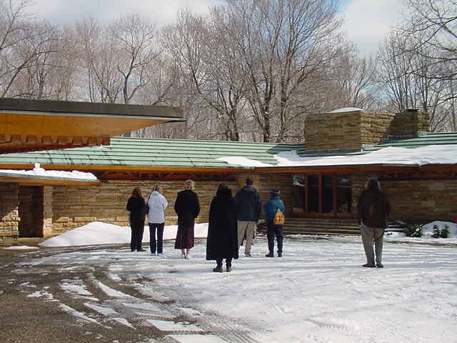 The carport (a Wright invention) is on the left. The green roof is copper.